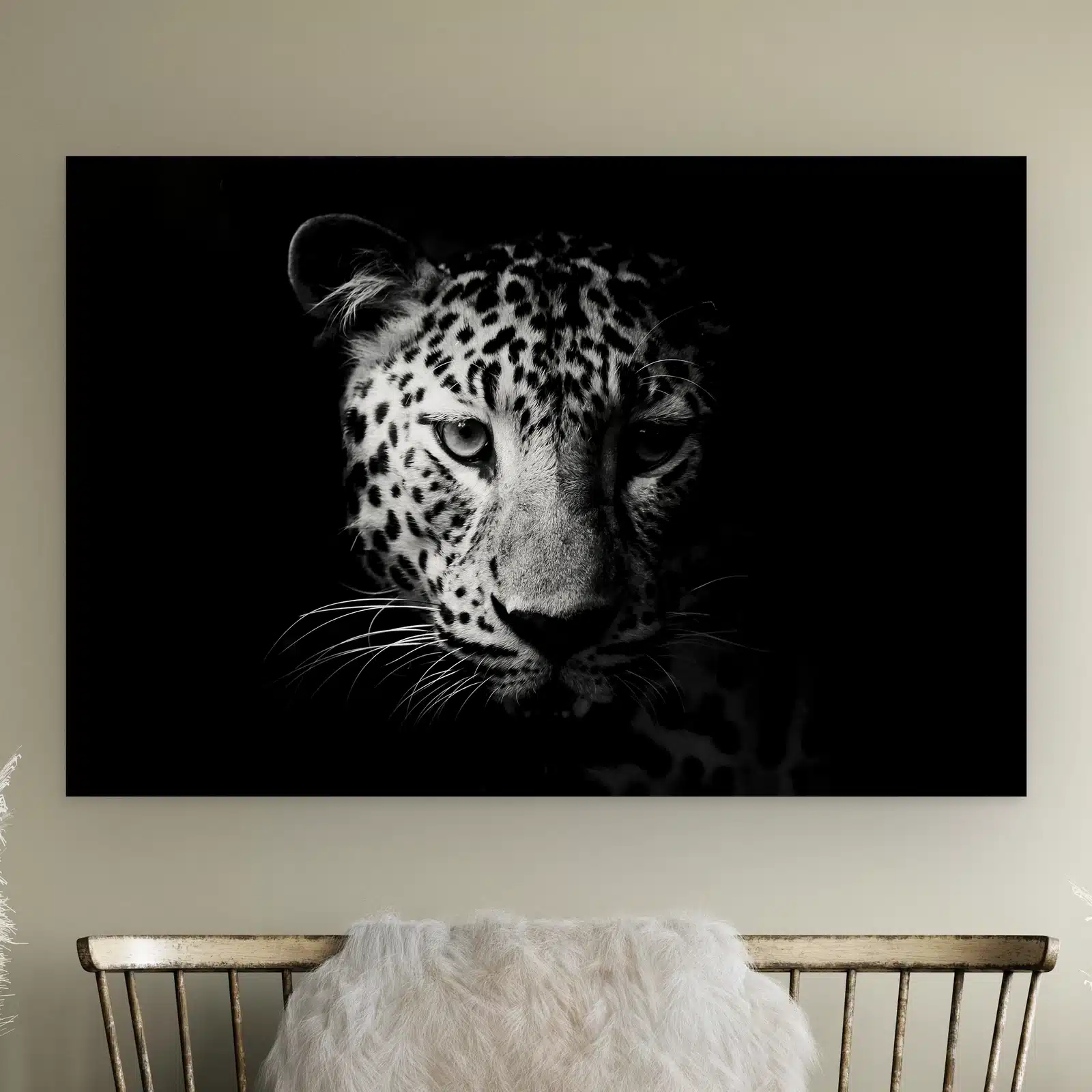 Luipaard portret aan de muur boven een houten bankje met schapenvacht