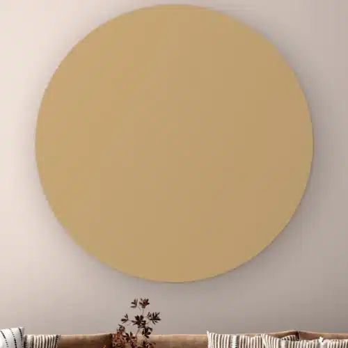 Muurcirkel Donker beige aan de muur boven een bank met gestreepte kussens