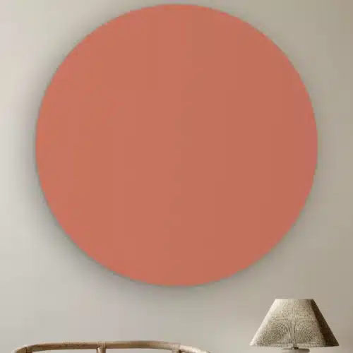 Muurcirkel Donker nude pink aan de muur boven een rotan stoel en een tafellamp