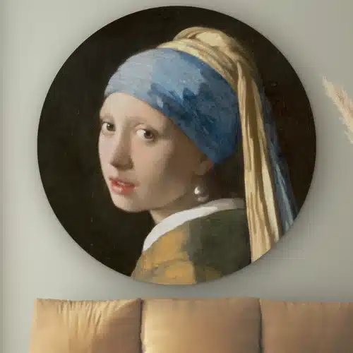 Muurcirkel Het meisje met de parel van Johannes Vermeer aan de muur boven een cognac bank