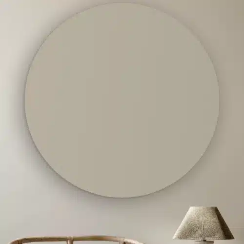 Muurcirkel Licht grijs aan de muur boven een rotan stoel en een tafellamp