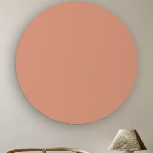 Muurcirkel Nude pink aan de muur boven een rotan stoel en een tafellamp