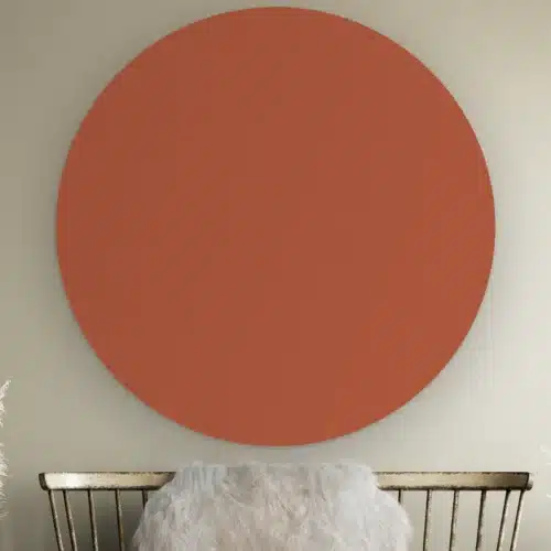 Muurcirkel Terracotta aan de muur boven een houten bankje met schapenvacht