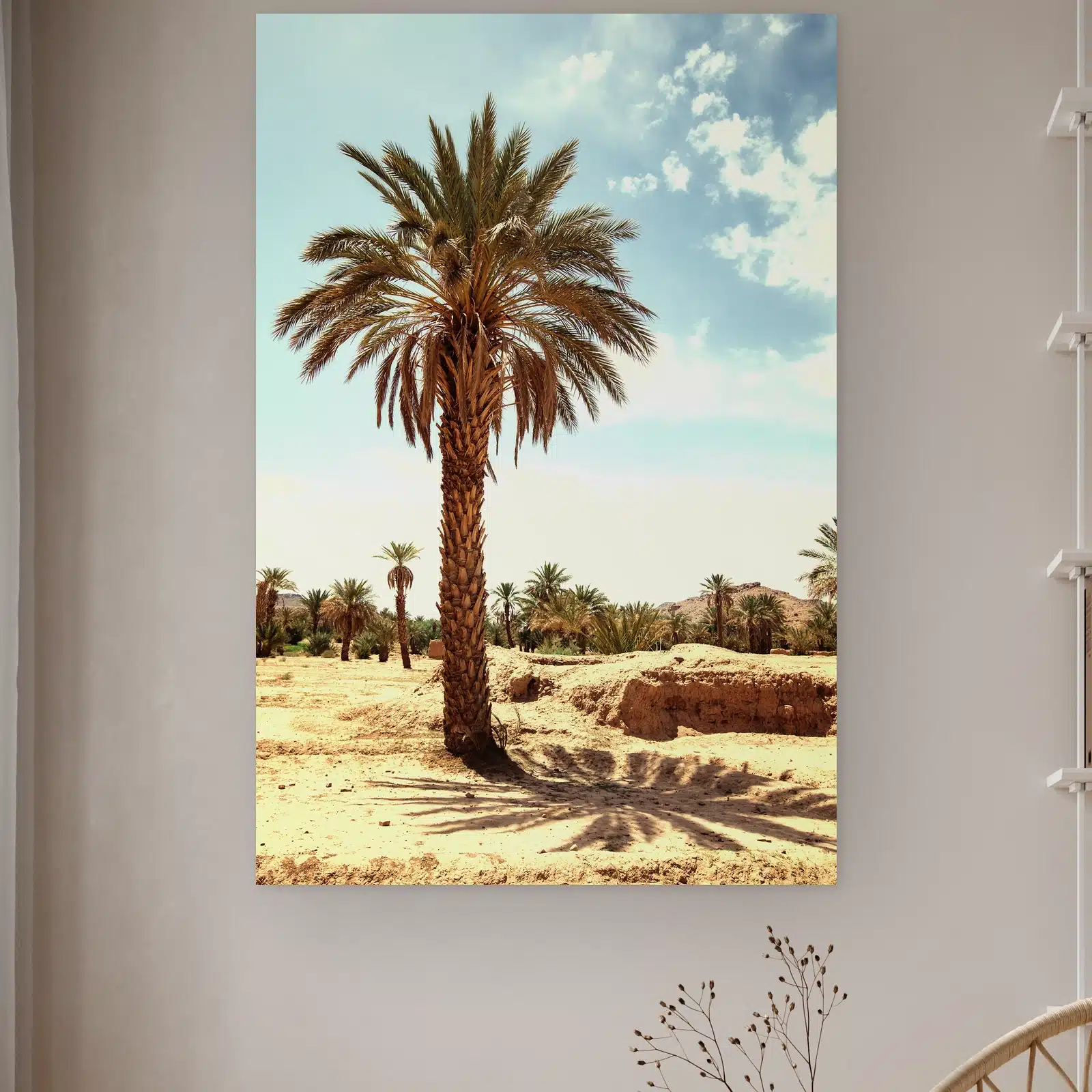 Palmboom aan de muur in een lichte kamer met droogbloemen