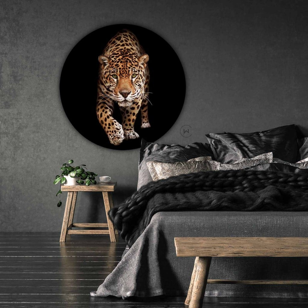 Muurcirkel wilde panter aan een donkergrijze wand boven een bed met grijs beddengoed