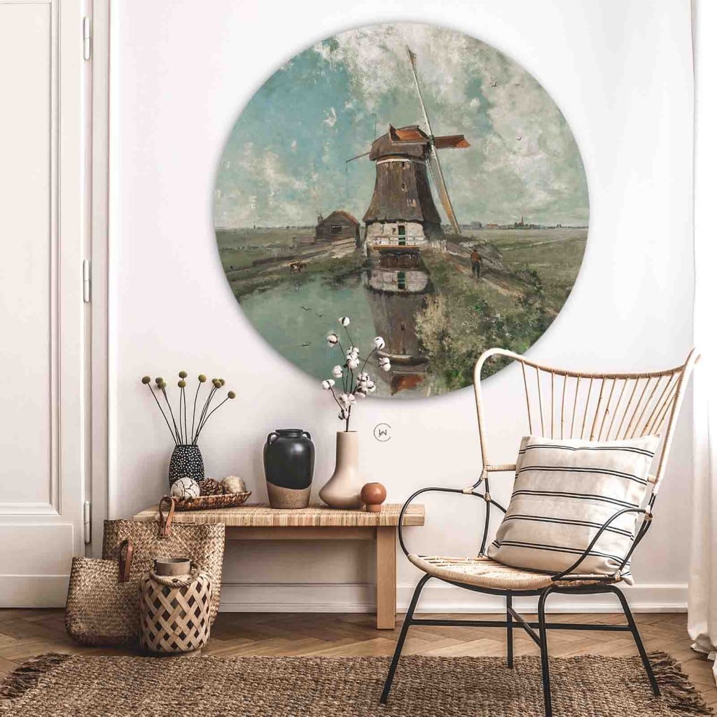 Muurcirkel een molen aan een poldervaart aan een witte wand boven een houten bankje en een rotan stoel