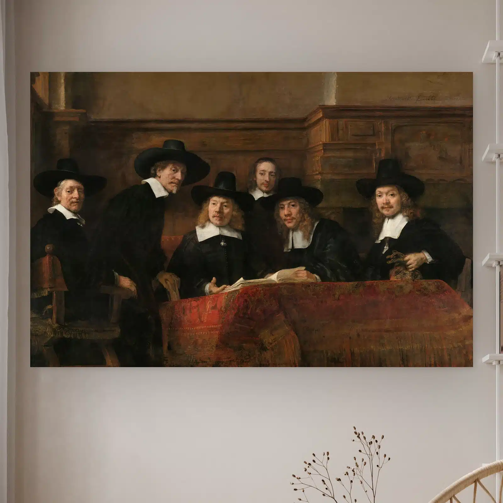 De Staalmeesters van Rembrandt van Rijn aan de muur in een lichte kamer met droogbloemen