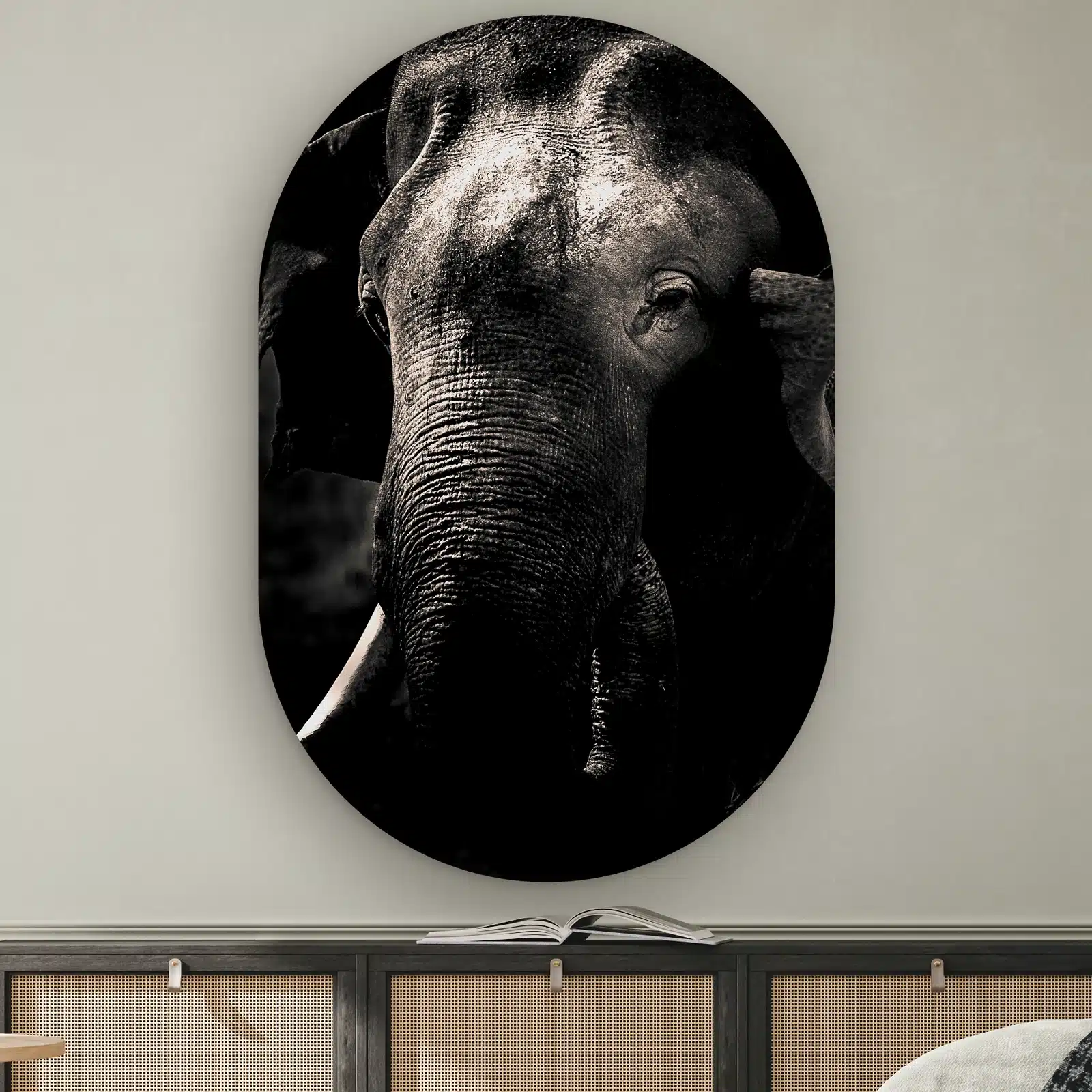 Muurovaal Olifant aan de muur boven een dressoir met rotan deurtjes