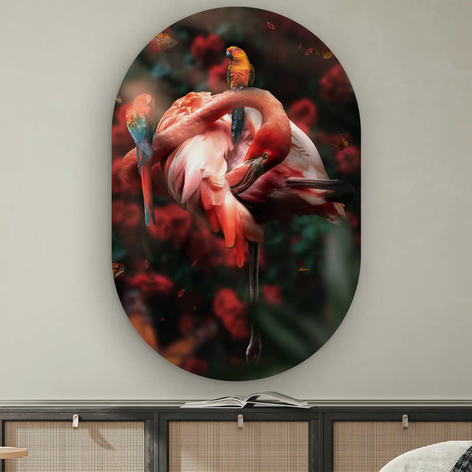 Muurovaal Flamingo met rozen aan de muur boven een dressoir met rotan deurtjes