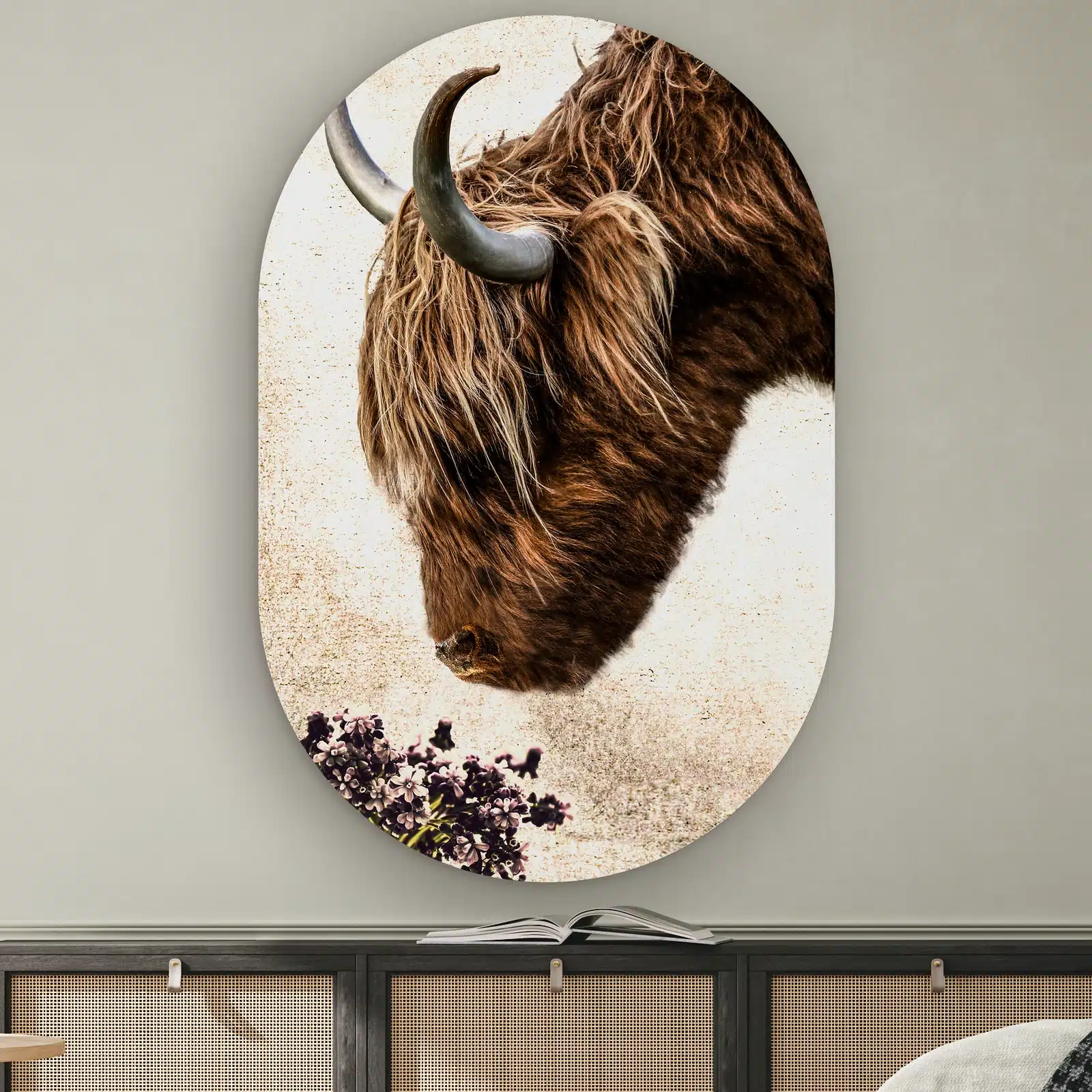 Muurovaal Vintage hooglander aan de muur boven een dressoir met rotan deurtjes