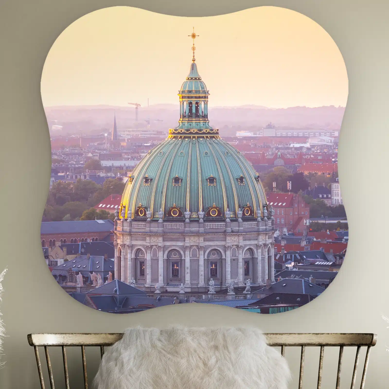 Organische vorm Frederikskerk Kopenhagen aan de muur boven een houten bankje met schapenvacht