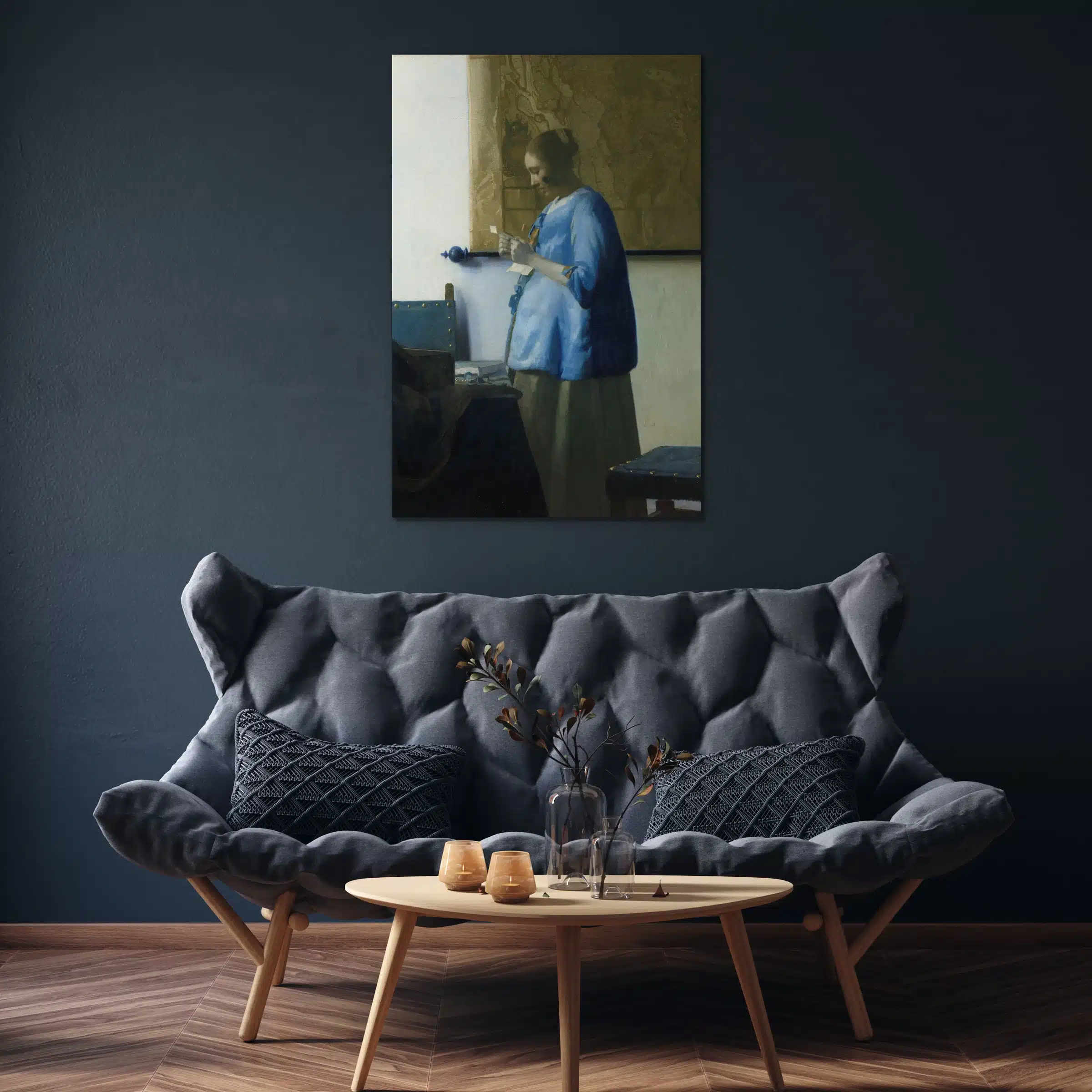 Brieflezende vrouw in het blauw van Vermeer boven een grijze bank tegen een donkerblauwe muur