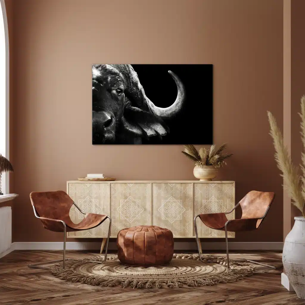 Buffel close-up aan een terracotta muur boven een houten dressoir tussen twee leren stoelen