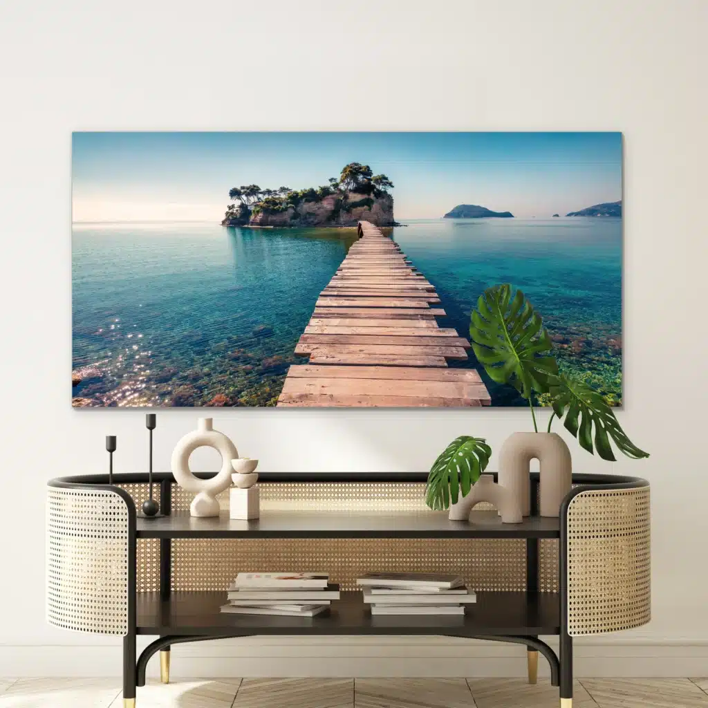 Cameo Island aan een witte muur boven een rotan console met een monstera