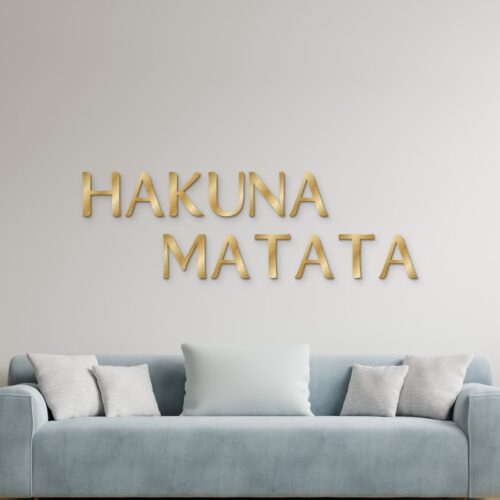 Hakuna Matata in goud geborsteld aluminium aan de muur boven een bank