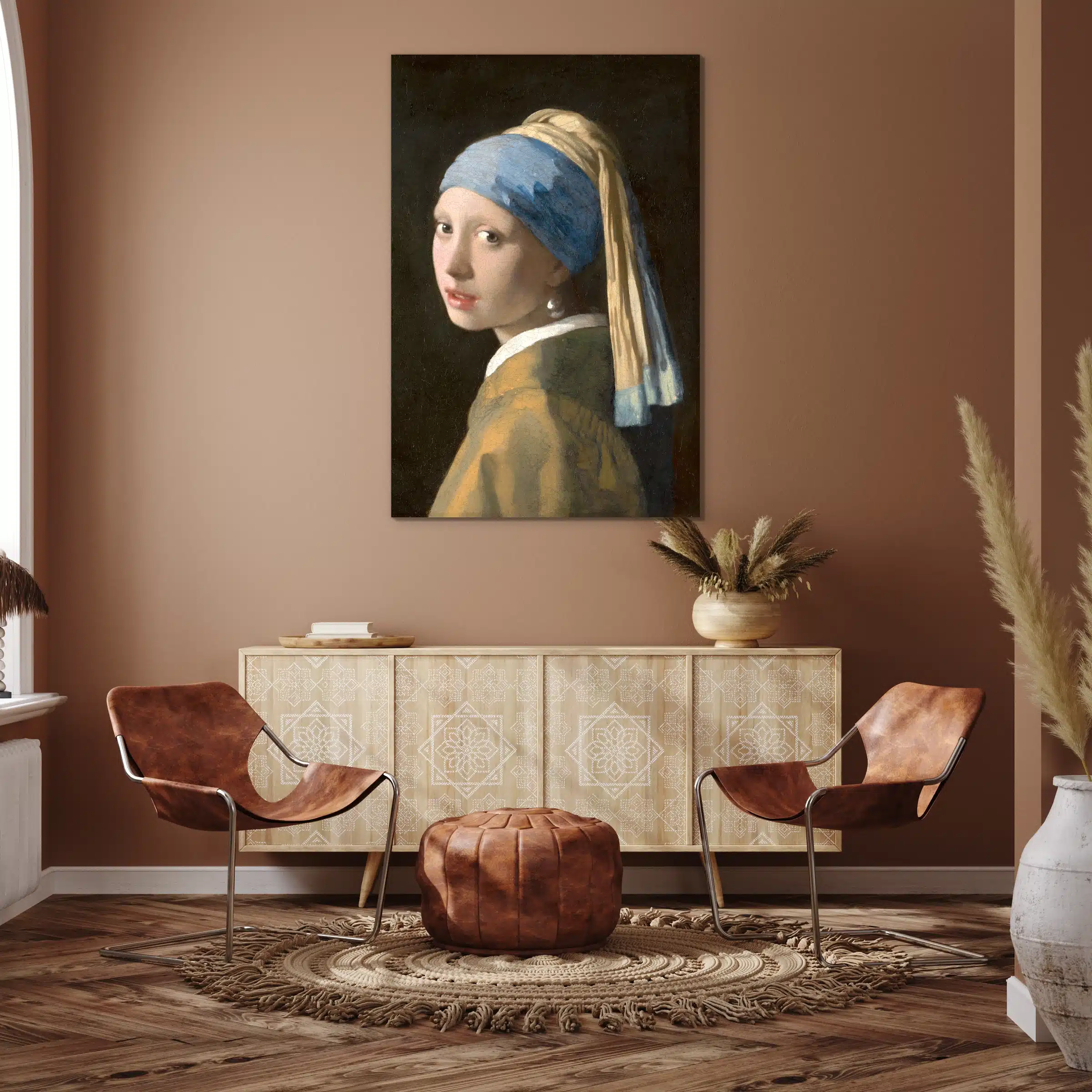 Het meisje met de parel van Vermeer boven een licht houten dressoir tegen een terracotta muur