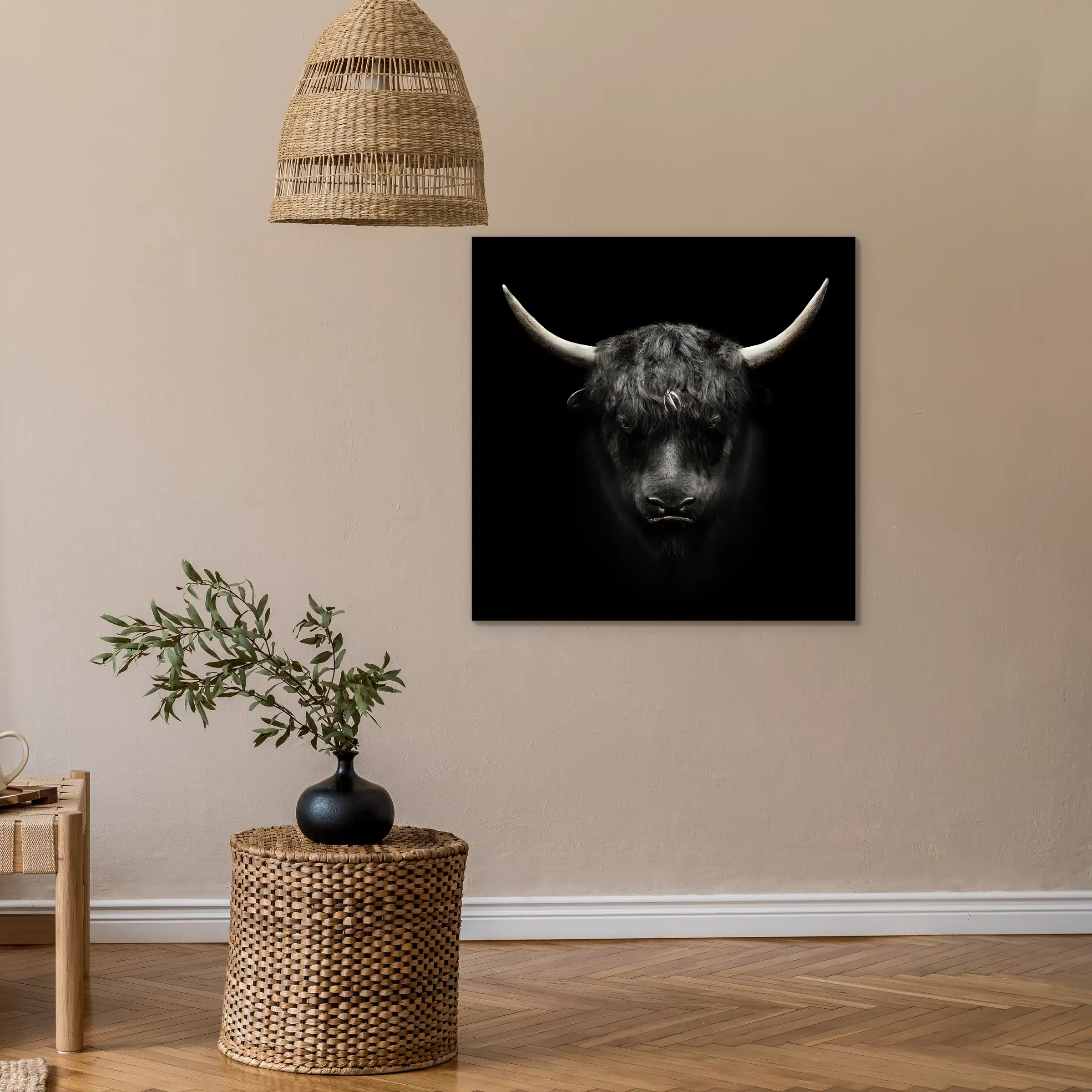 Jak aan een beige muur onder een rieten hanglamp, met een rieten bijzettafel