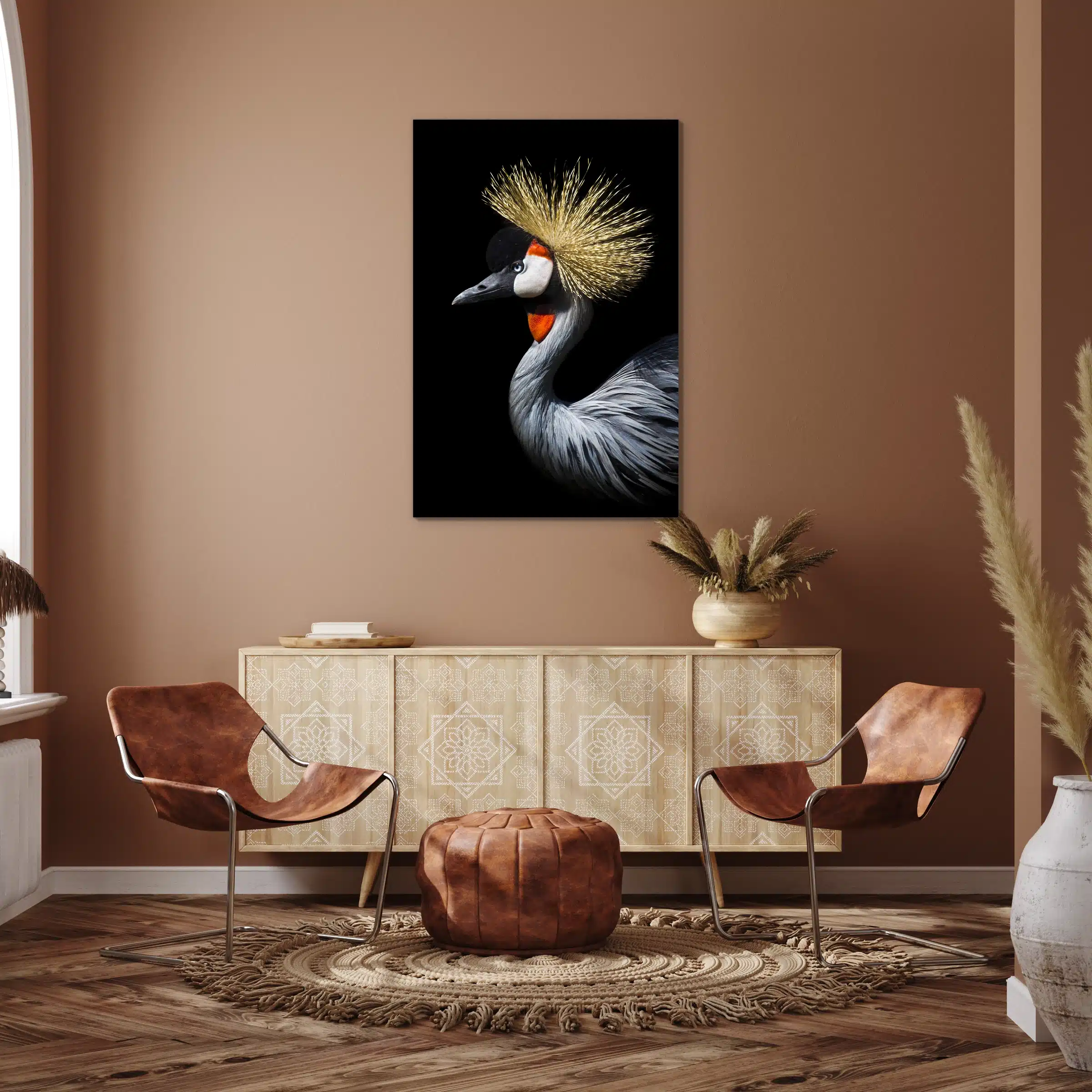 Kraanvogel met kuif aan een terracotta muur boven een licht houten dressoir met leren stoelen