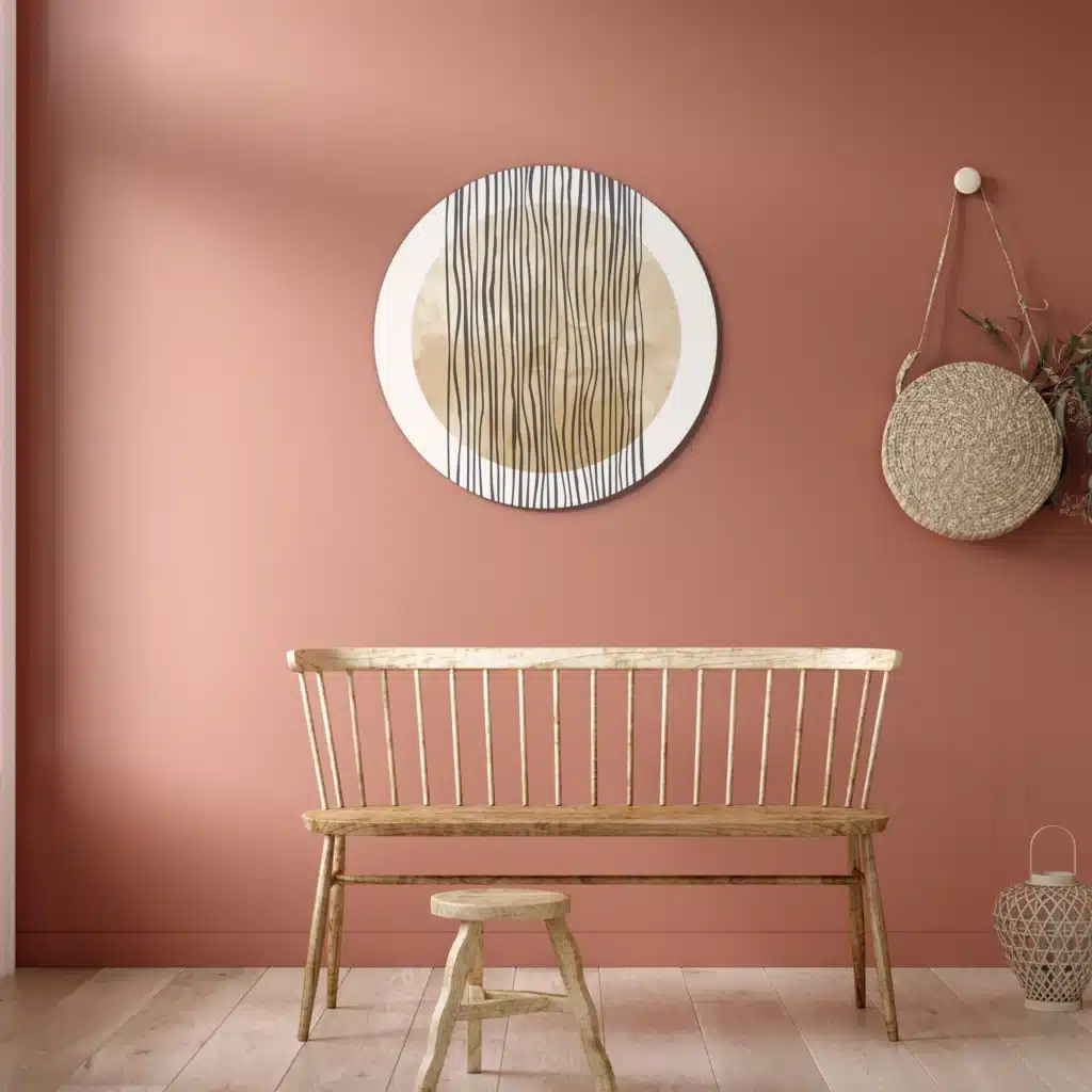 Muurcirkel abstracte vallende strepen boven een houten bank tegen een terracotta muur