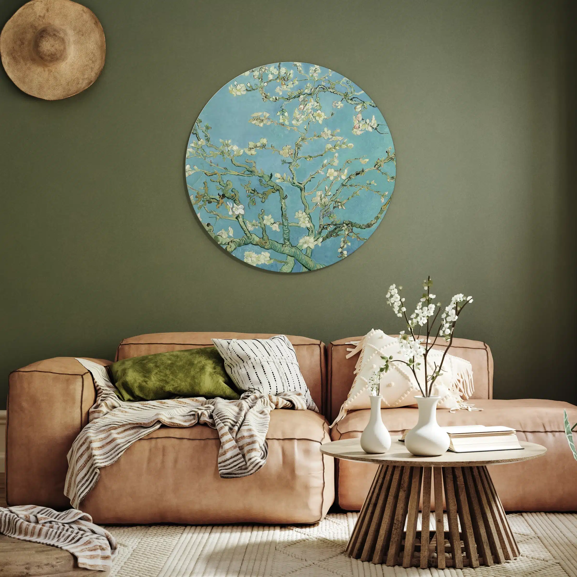 Muurcirkel amandelbloesem van Van Gogh aan een olijfgroene muur boven een cognac leren bank