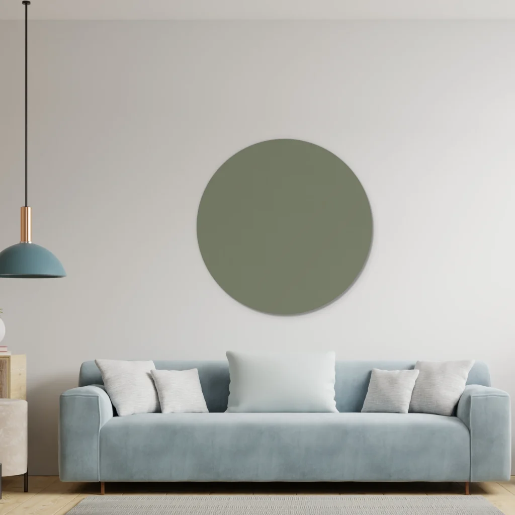 Army green muurcirkel boven een lichtblauwe bank met een blauwe hanglamp