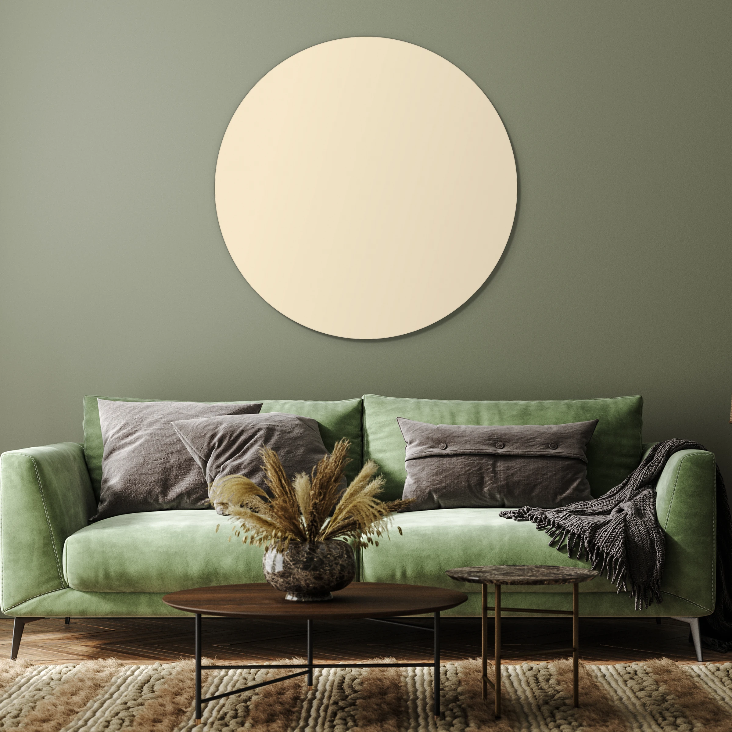 Muurcirkel beige aan een olijfgroene wand boven een groene bank met grijze kussens