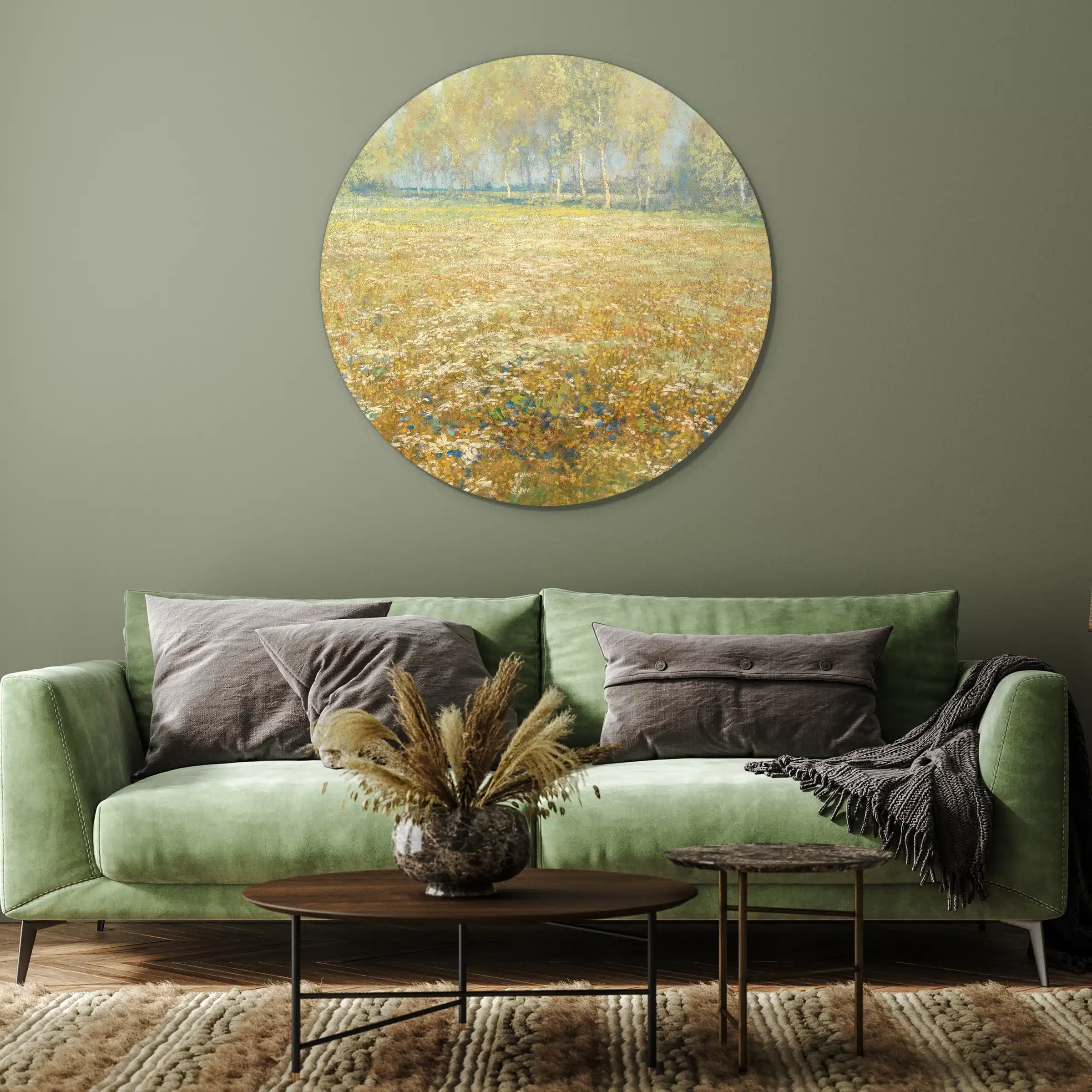 Bloemenweide schilderij als muurcirkel aan een groene muur boven de bank