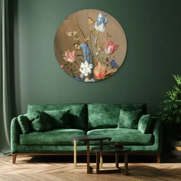 Schilderij bloemen in vaas als muurcirkel aan een groene muur boven een fluwelen bank