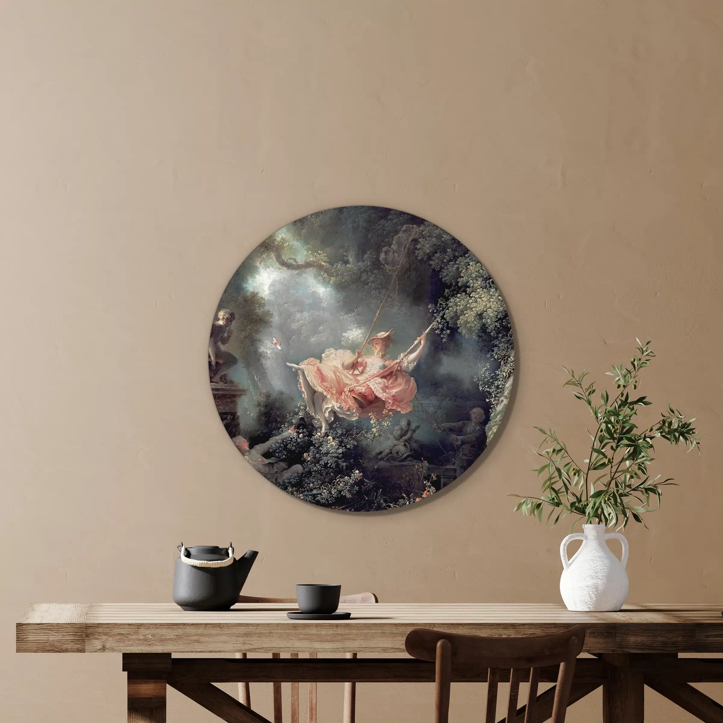 Muurcirkel de schommel van Fragonard aan een zandbeige wand boven een houten tafel met een witte kruik