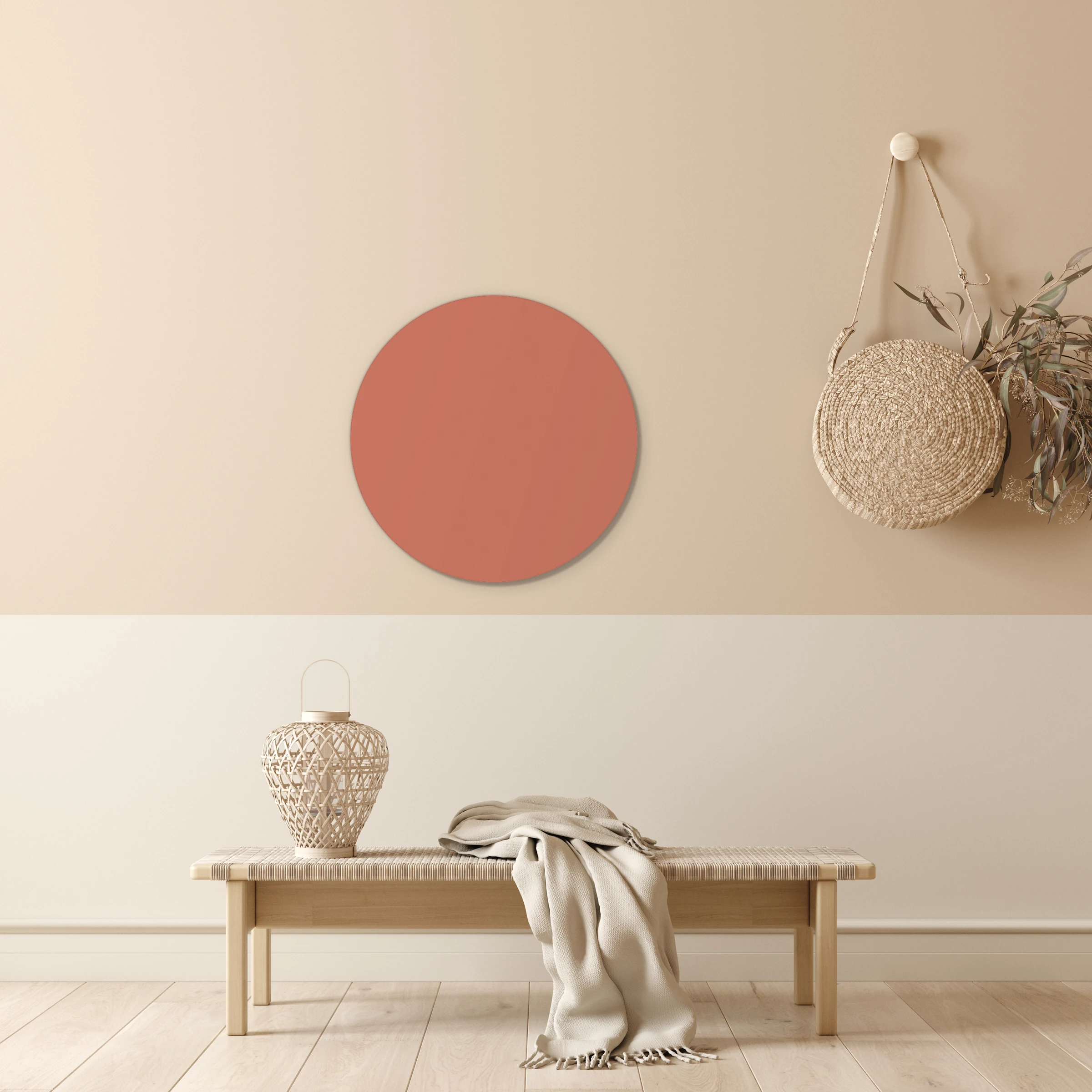 Muurcirkel donker nude pink boven een geweven bankje tegen een beige muur met witte lambrisering