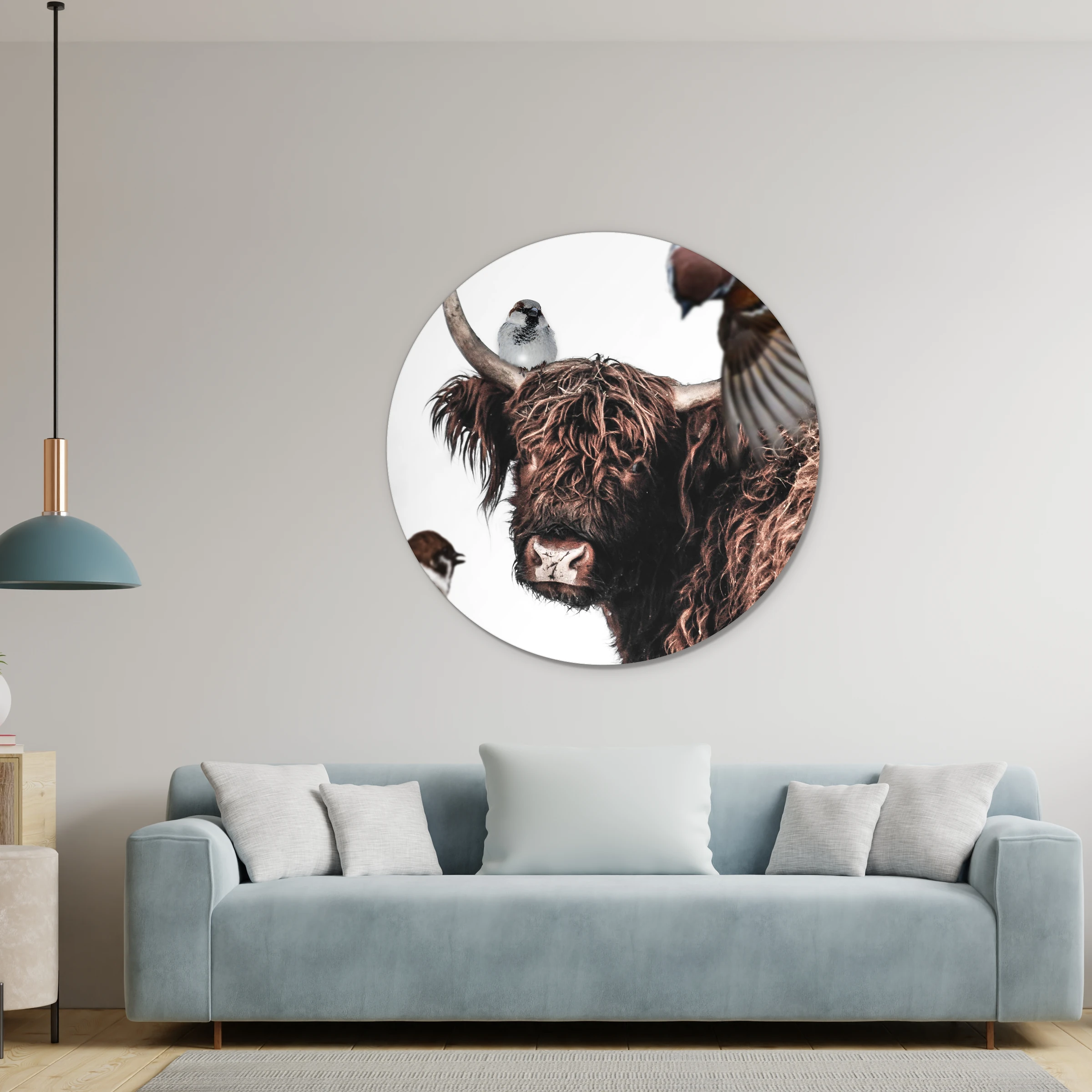 Muurcirkel hooglander artistiek aan een lichtgrijze wand boven een lichtblauwe bank, met een hanglamp
