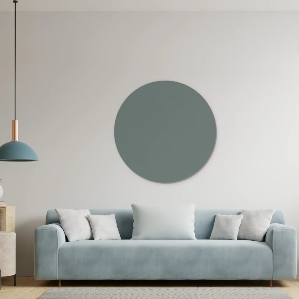 Licht petrol muurcirkel boven een lichtblauwe bank met een blauwe hanglamp