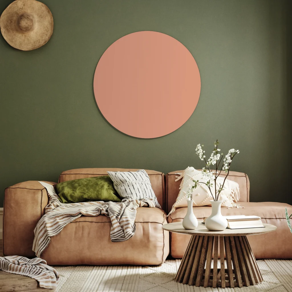 Muurcirkel nude pink boven een cognac leren bank tegen een olijfgroene muur