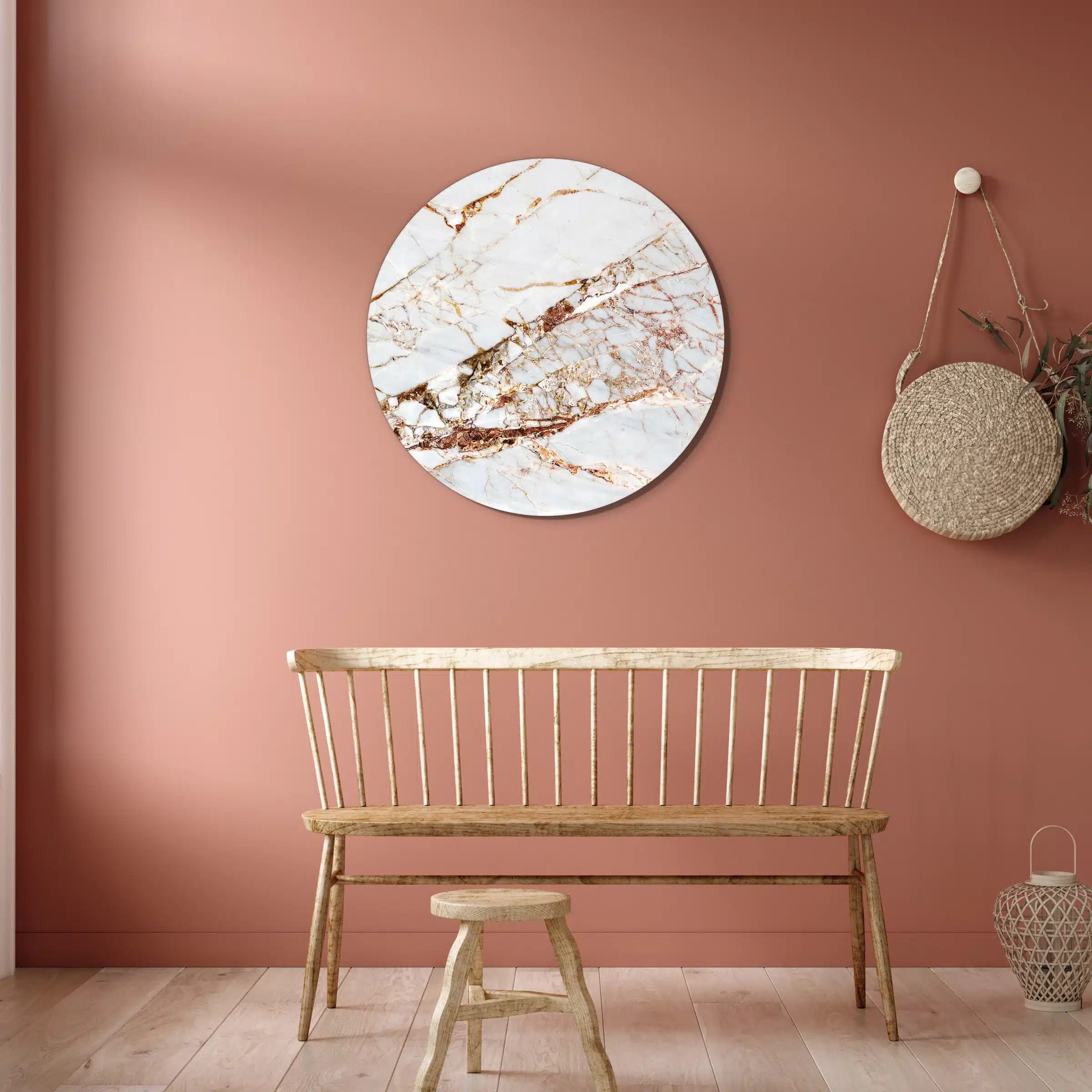 Muurcirkel rose gouden marmer boven een houten spijlenbank tegen een terracotta muur