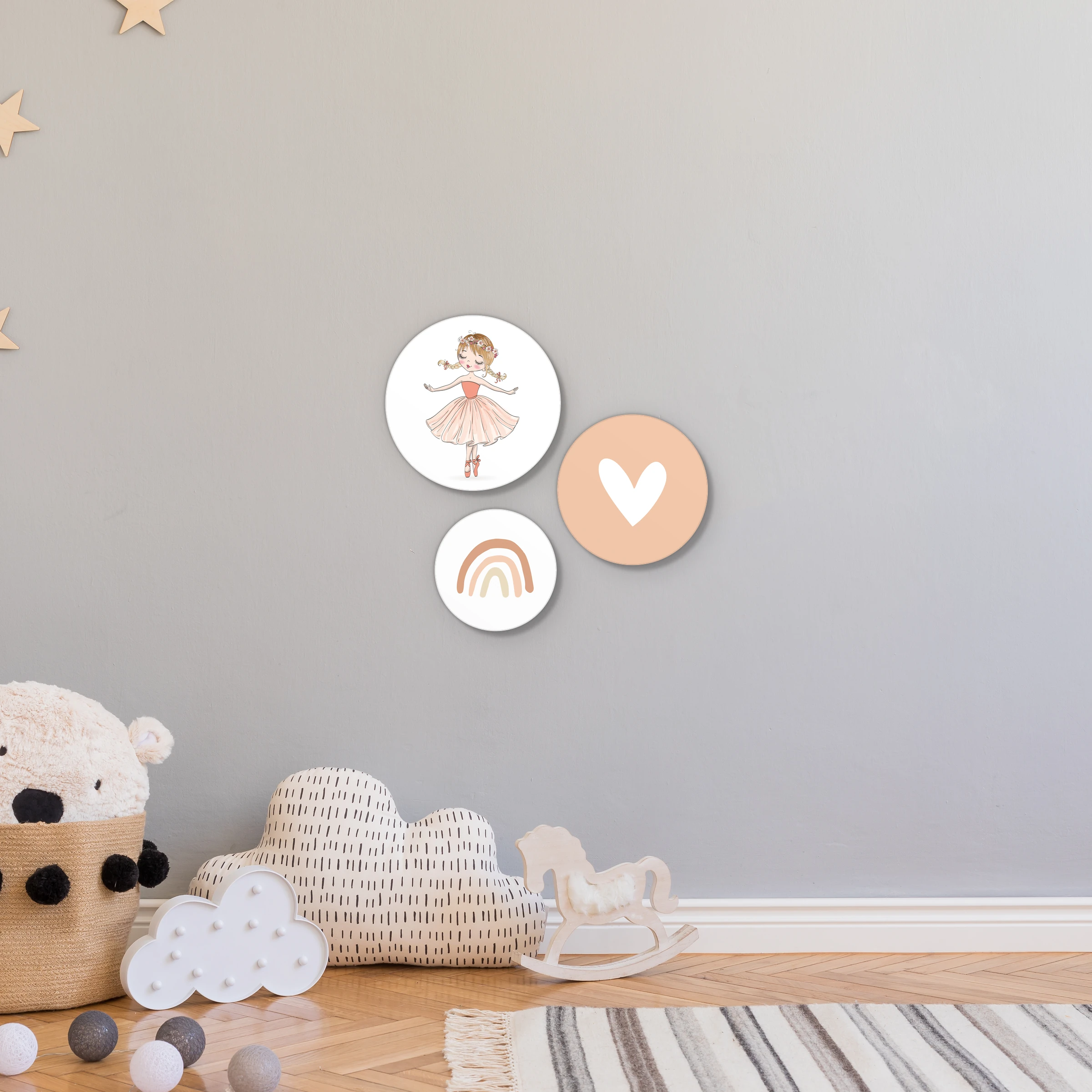 Muurcirkel set ballerina aan een lichtgrijze wand in een kinderkamer met houten sterren en knuffels