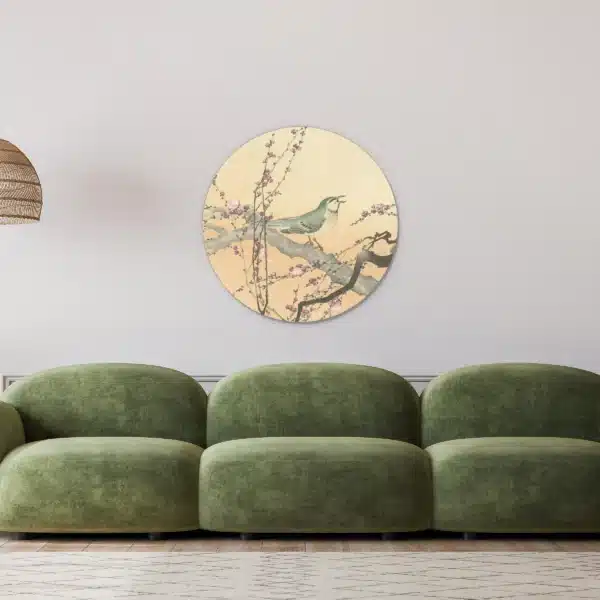 Japanse prent vogel als muurcirkel in een lichte woonkamer boven een groene bank