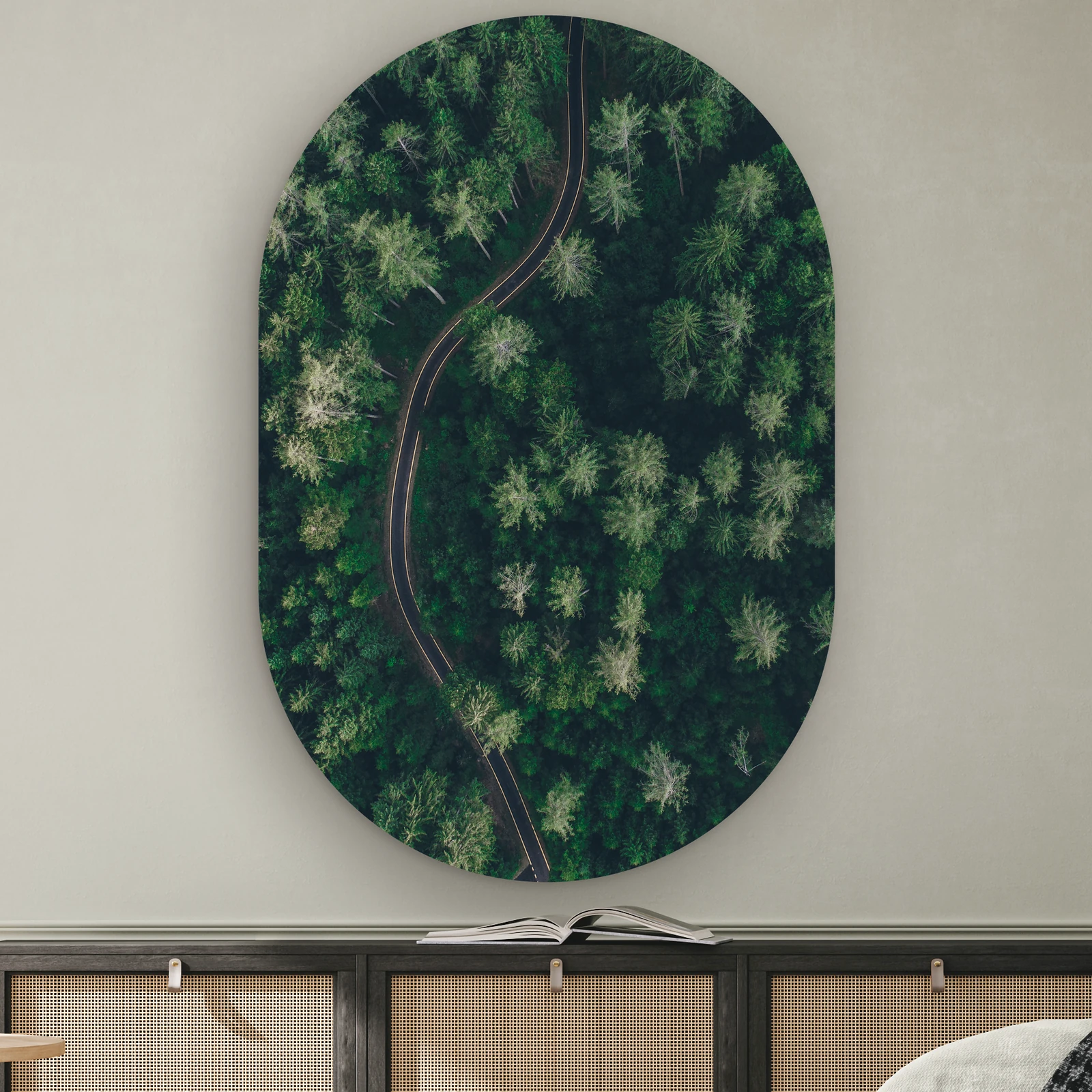 Muurovaal De groene weg aan de muur boven een dressoir met rotan deurtjes