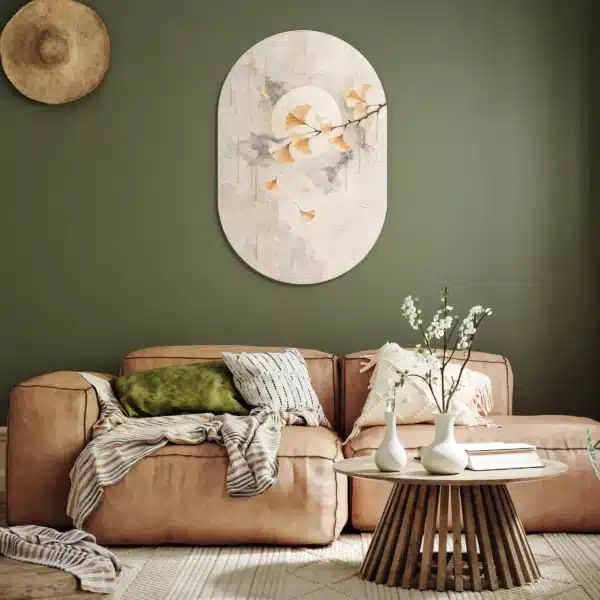 Ginkgo wanddecoratie als muurovaal aan een olijfgroene muur boven een cognackleurige bank
