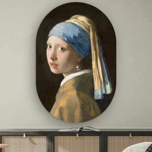 Muurovaal Meisje met de parel aan de muur boven een dressoir met rotan deurtjes