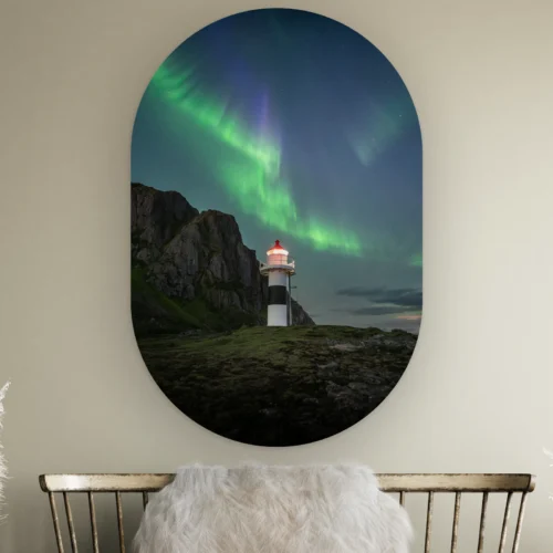 Muurovaal Noorderlicht vuurtoren Lofoten aan de muur boven een houten bankje met schapenvacht