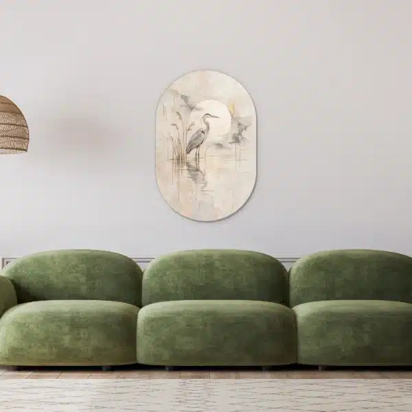 Schilderij blauwe reiger als muurovaal in een lichte woonkamer boven een groene bank