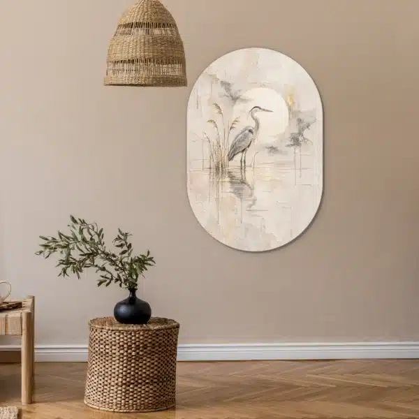 Schilderij blauwe reiger als muurovaal aan een zandkleurige muur