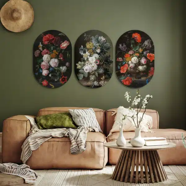 Bloemen drieluik in drie muurovalen aan een olijfgroene muur boven een cognackleurige bank