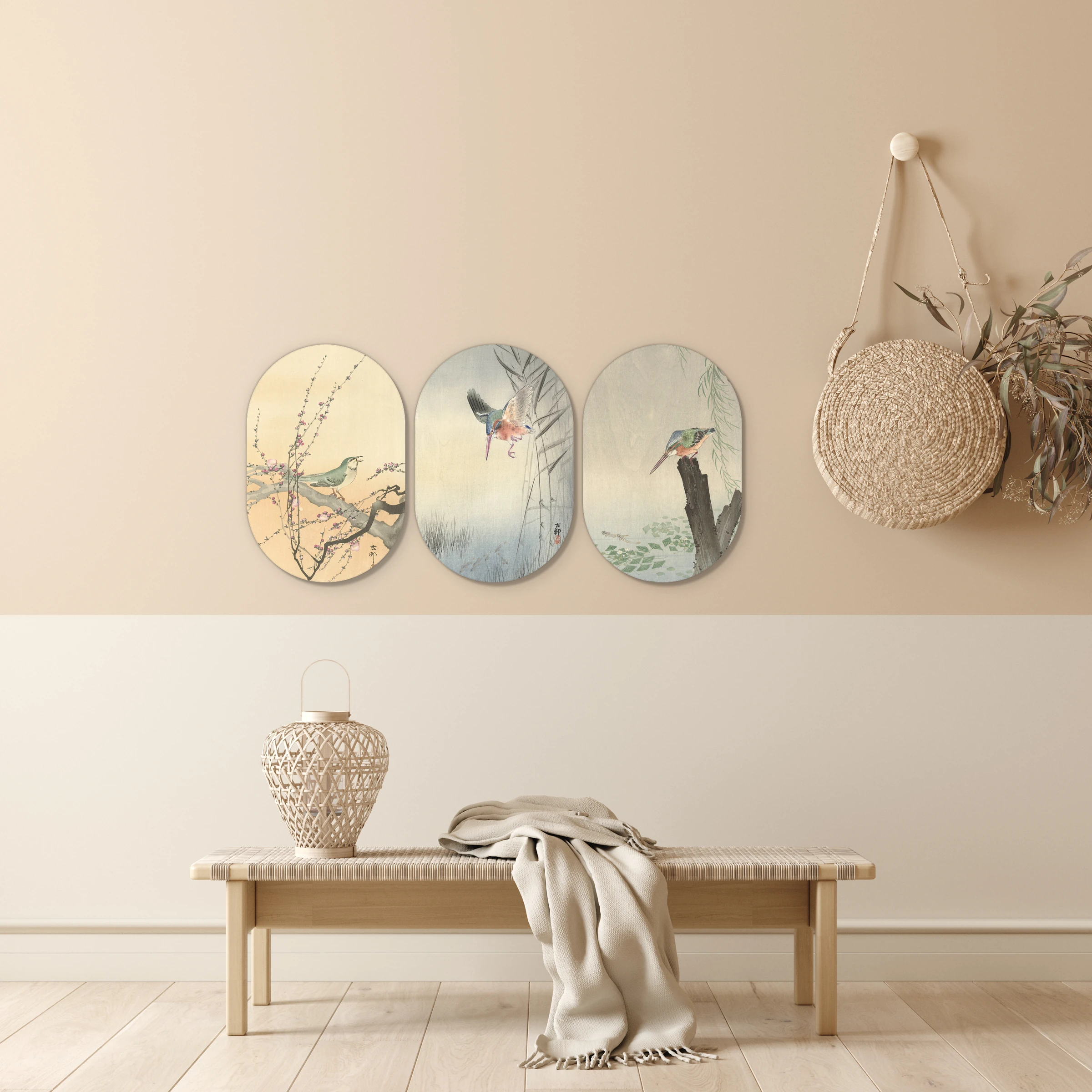 Japanse schilderijen van Koson als drieluik in muurovalen in een lichte hal boven een houten bankje