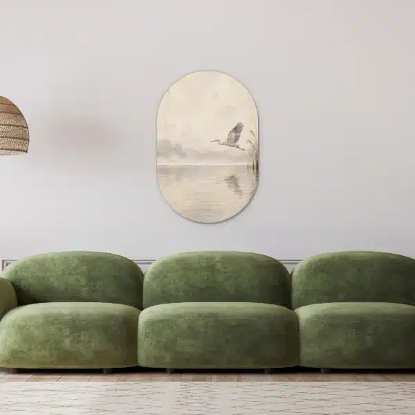 Muurovaal reiger in een lichte woonkamer boven een groene bank