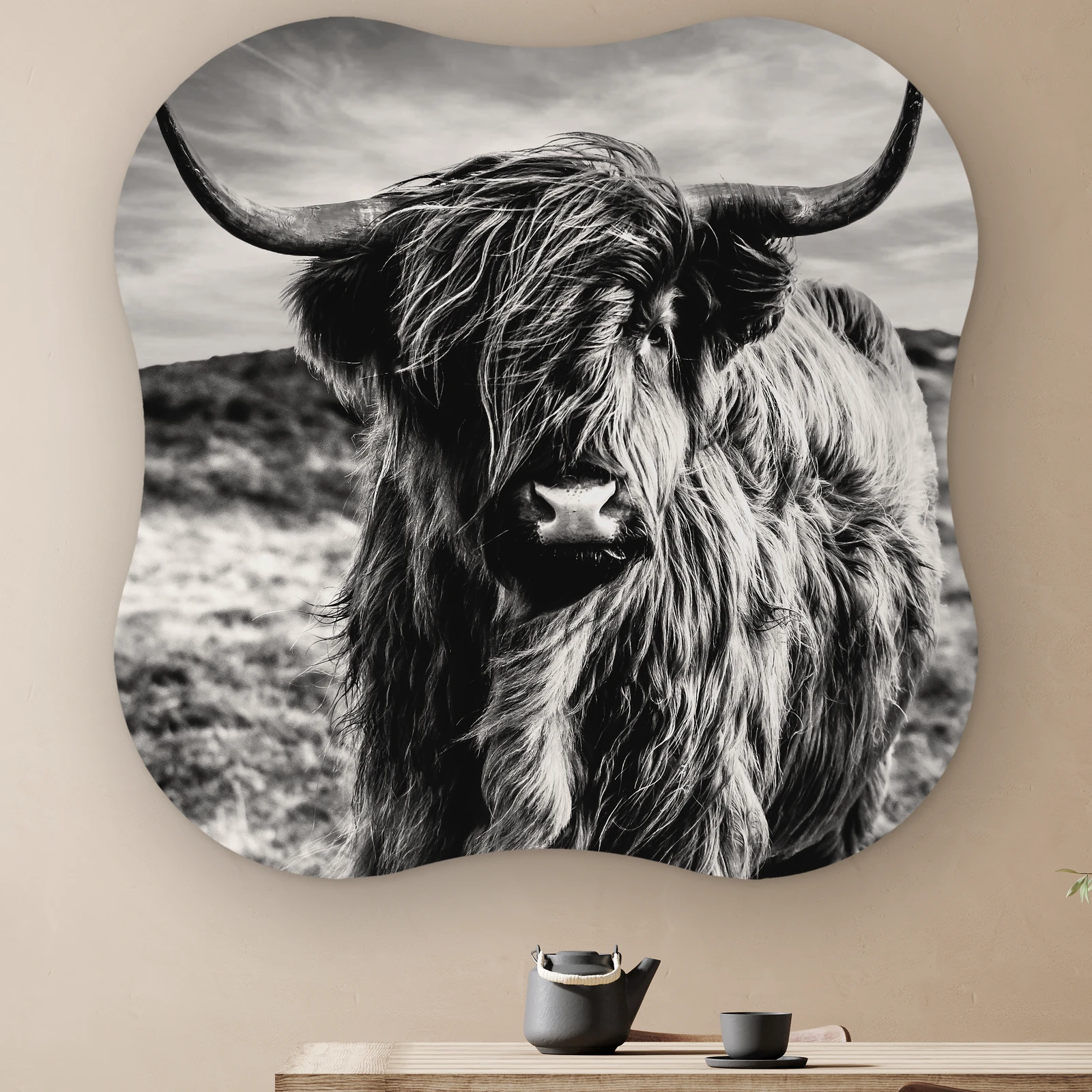 Organische vorm Schotse hooglander zwart wit aan de muur boven een houten tafel met theepot