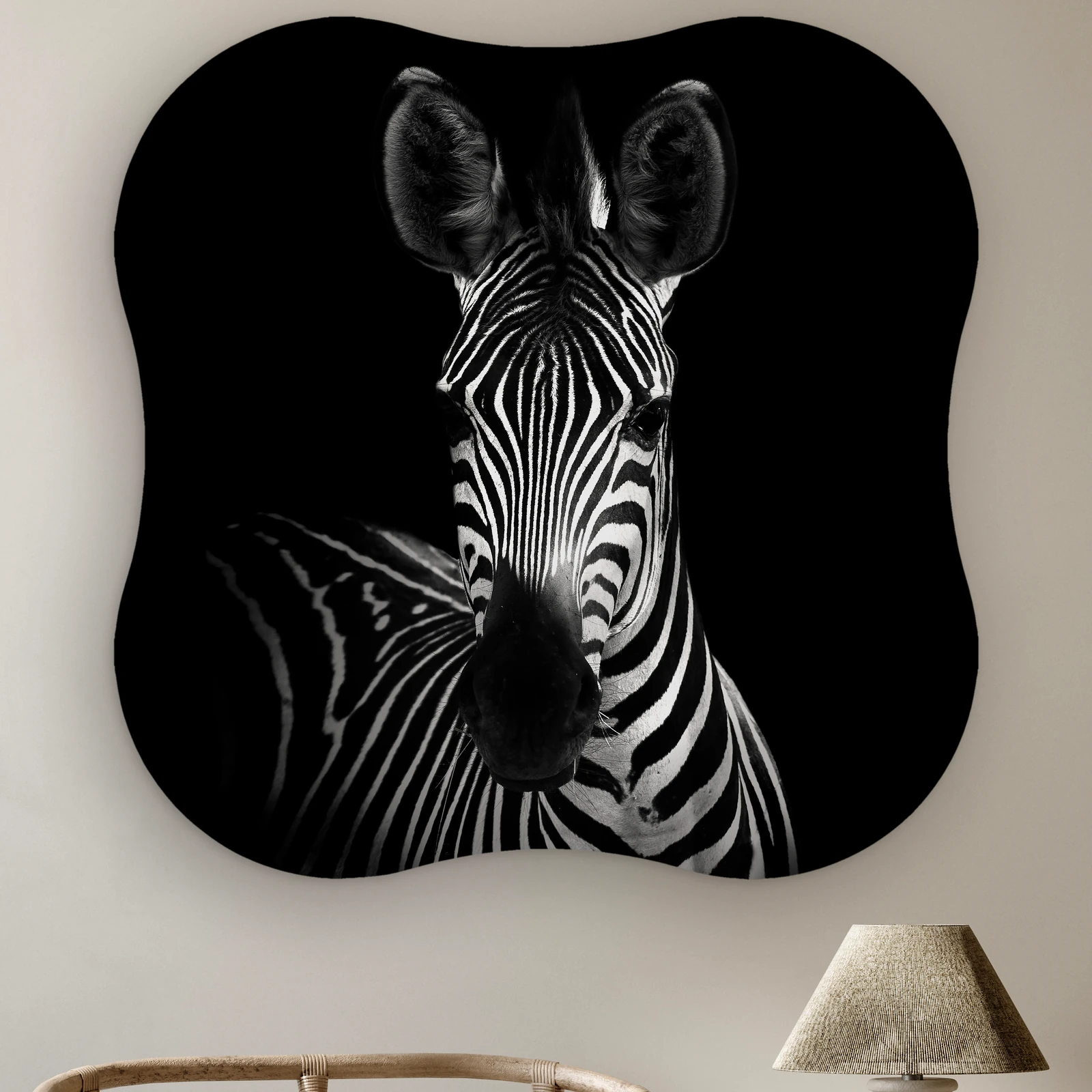 Organische vorm Zebra portret zwart wit aan de muur boven een rotan stoel en een tafellamp