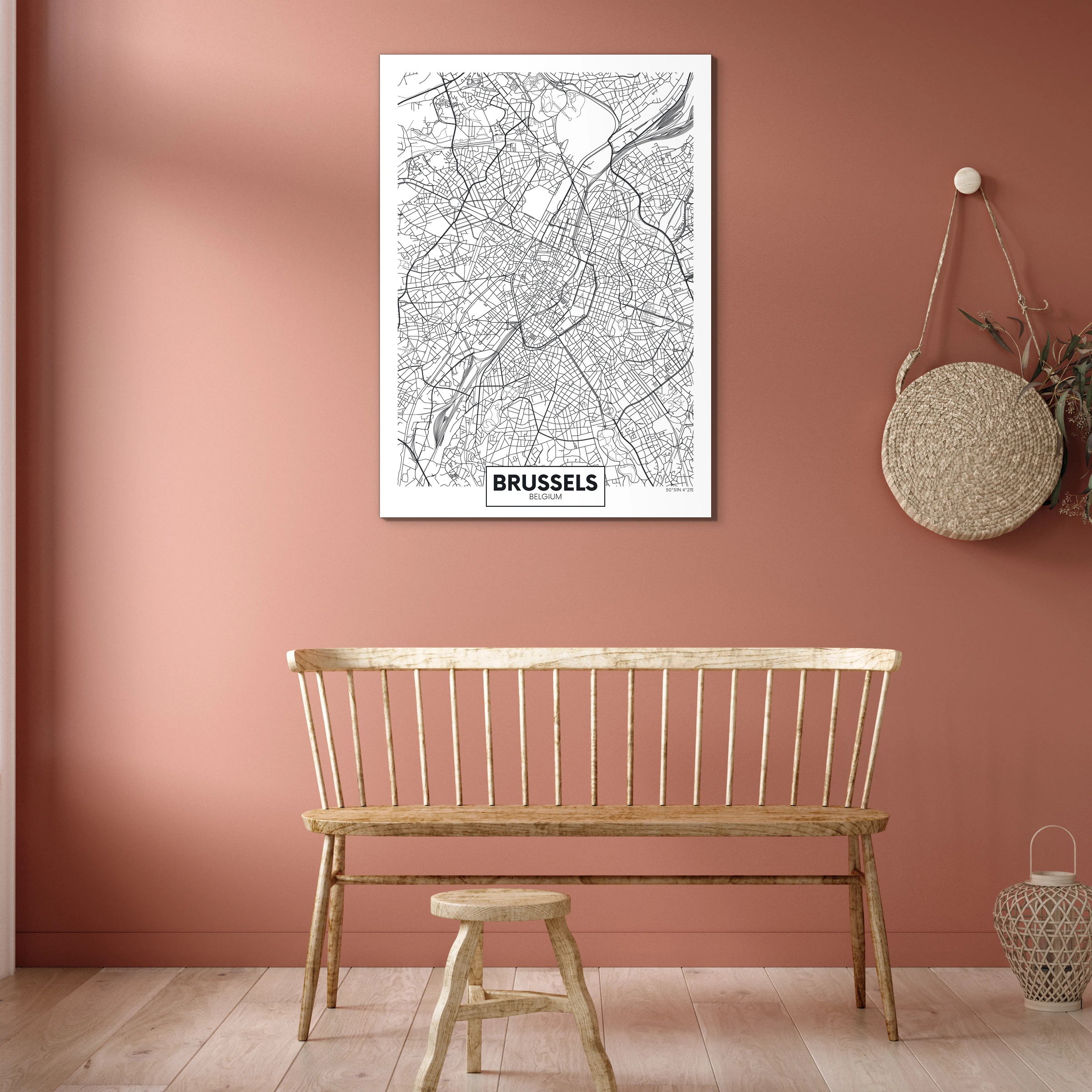 Plattegrond Brussel aan een terracotta muur boven een houten spijlenbank
