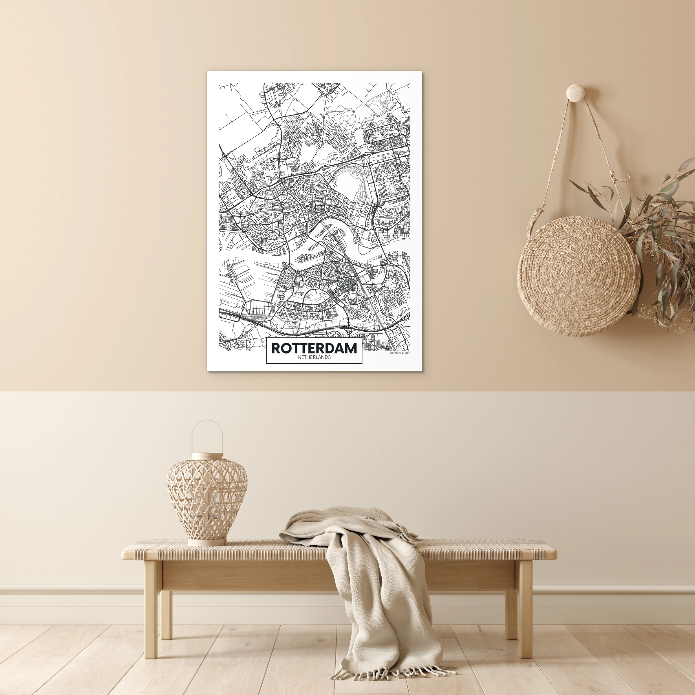 Plattegrond Rotterdam in zwart-wit aan een beige muur boven een geweven bankje