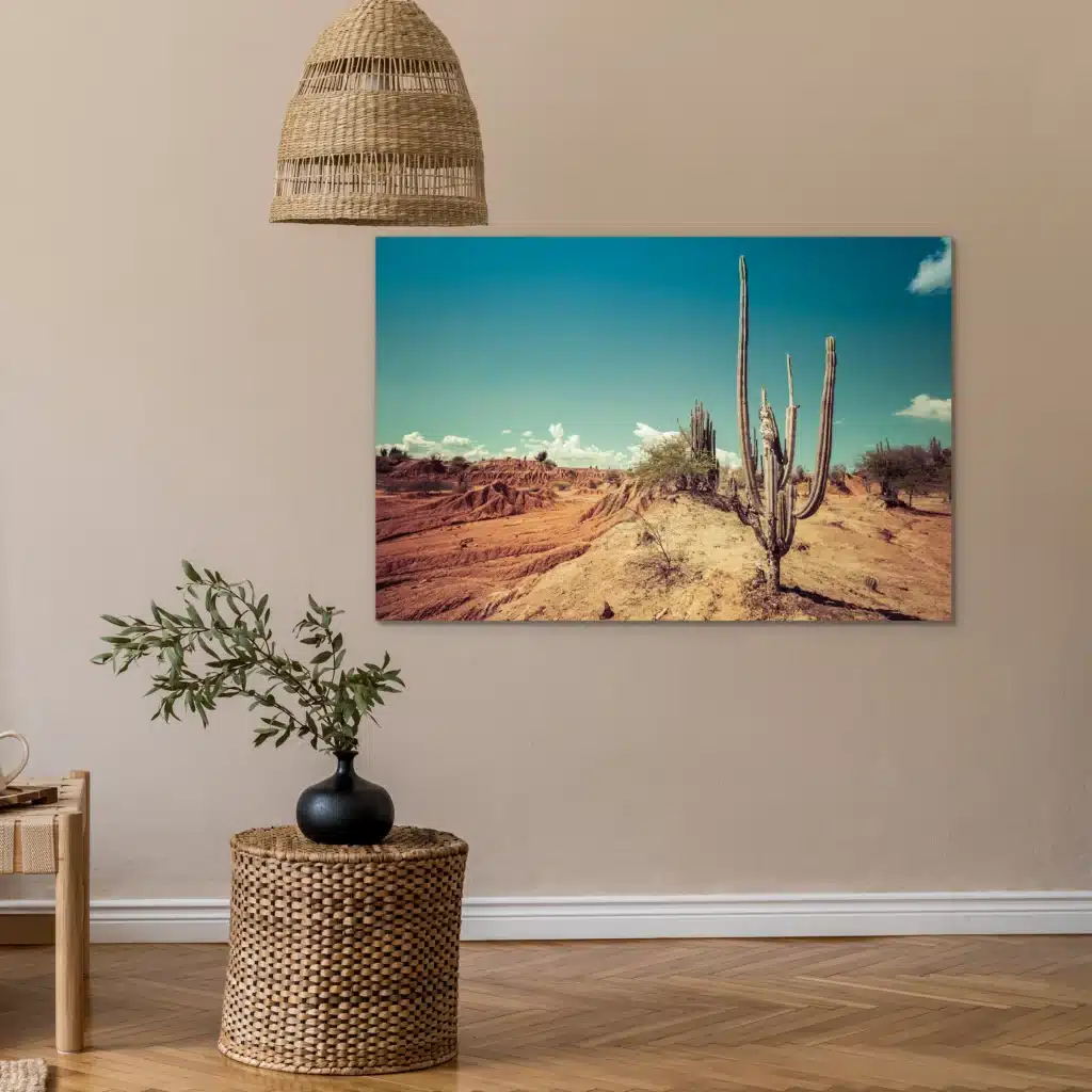 Rode woestijncactus aan een beige muur boven een rieten bijzettafel, onder een rieten hanglamp